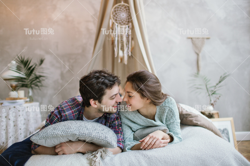 年轻的潮夫妇在手工床上玩捕梦网