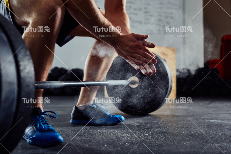 特写举重运动员拍手之前的杠铃锻炼