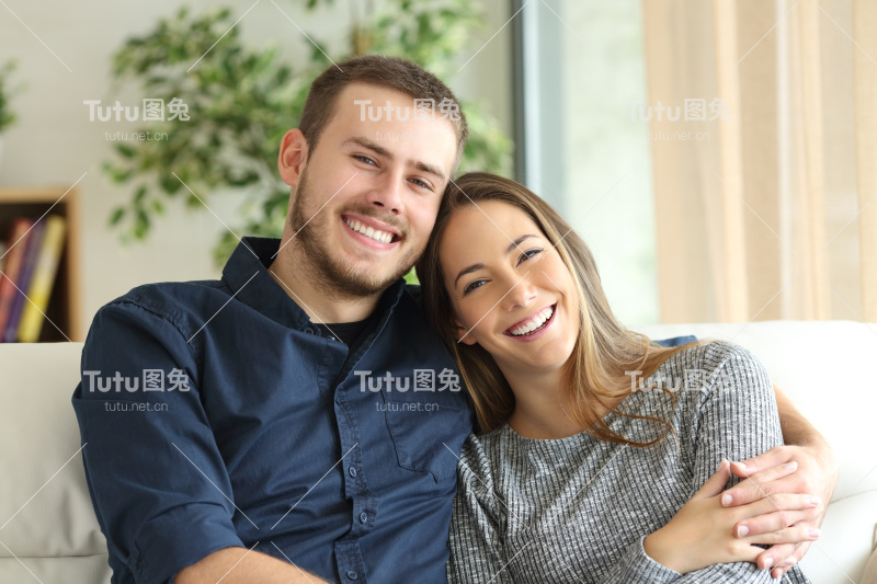 一对在家里看着摄像机的幸福夫妇