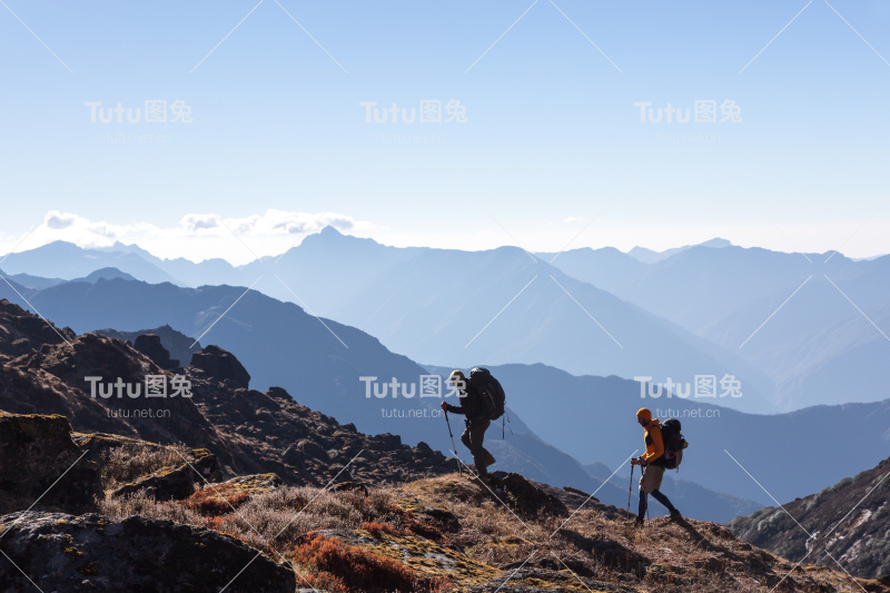 背着背包、拄着拐杖在山里旅行的人