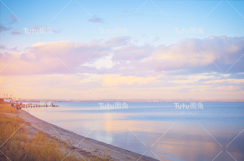 天空背景日落，海滨。自然成分。全景日落天空背景。美丽的日落在海上与水的反射，雄伟的云在天空。