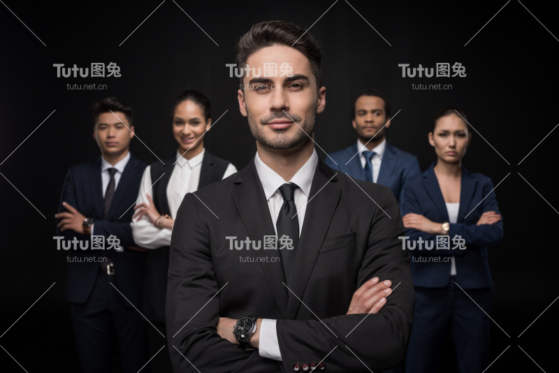 自信的商人站在一群商业伙伴的后面