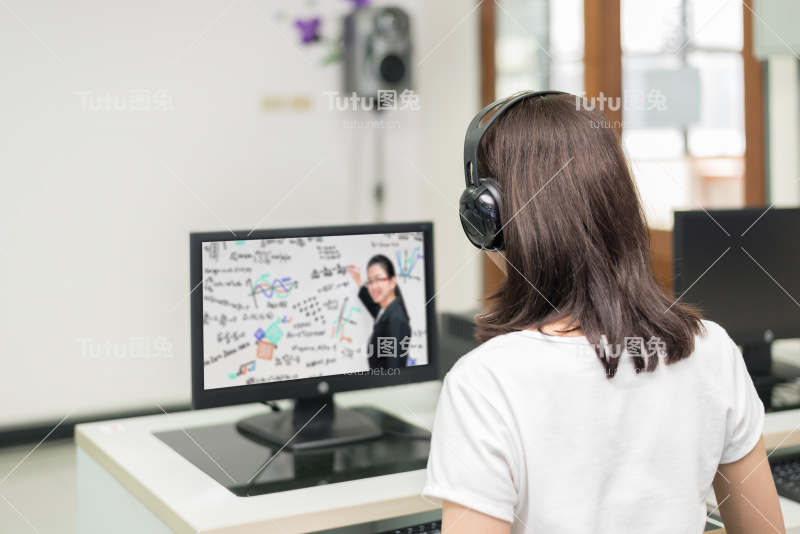 亚洲女学生在大学资讯科技室与老师在电脑上进行电子学习视频会议。E-learning,online,education concept。