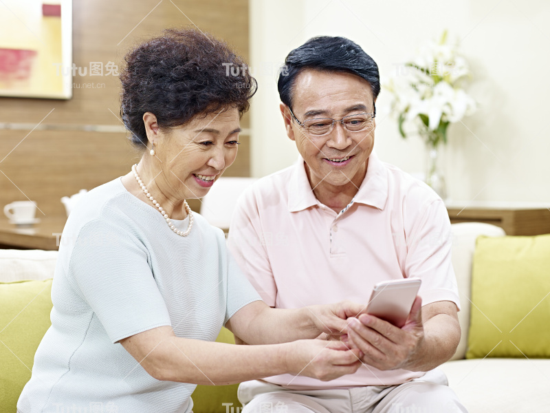 一对亚洲老夫妇一起用手机
