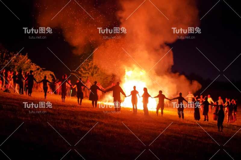 人们手牵着手围着火