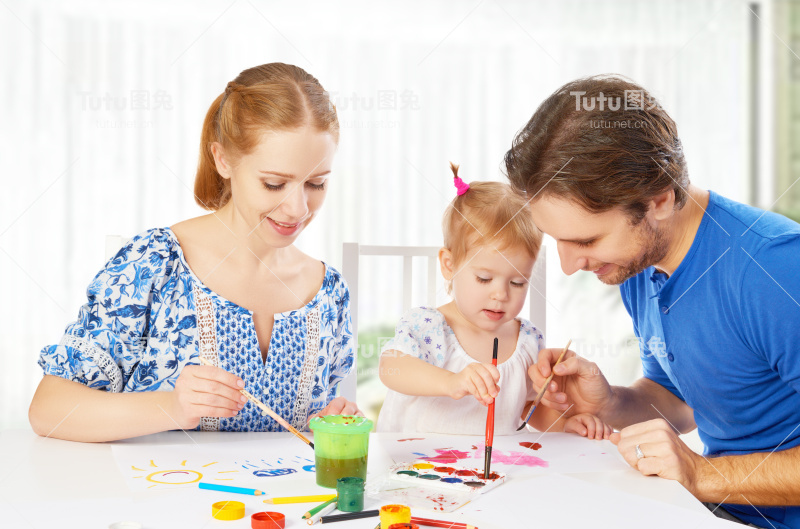 幸福家庭:妈妈，爸爸和孩子女儿画颜料