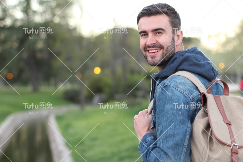 笑脸男在户外拿着背包