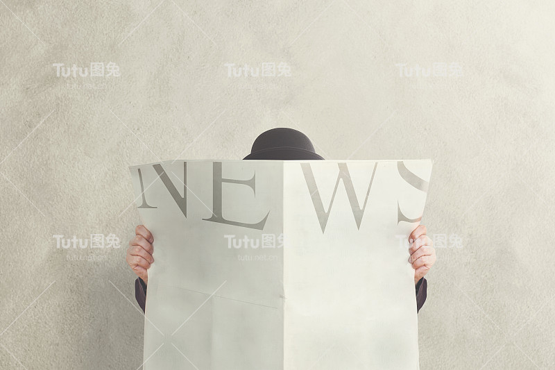 拿着礼帽看新闻的人