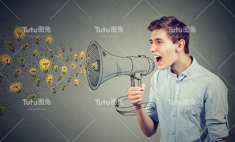 在灰色墙壁的孤立背景下，一个人用扩音器大声喊出他的想法