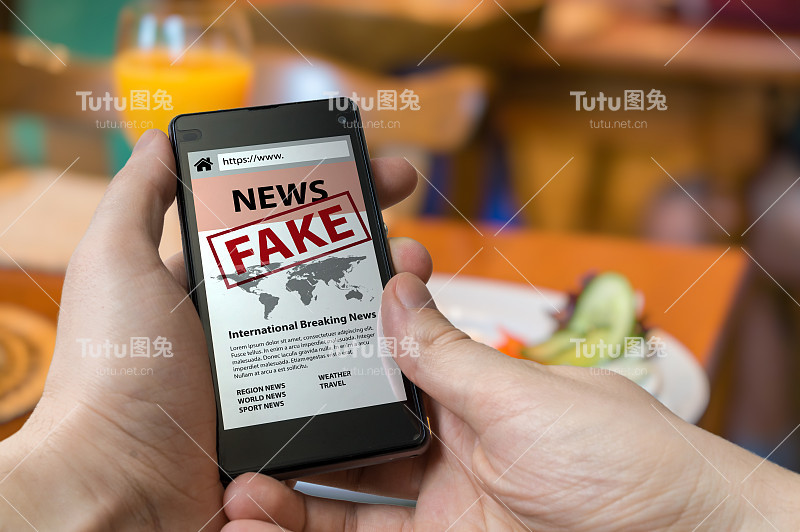 男人拿着智能手机在网上看假新闻。宣传、虚假信息和骗局的概念。