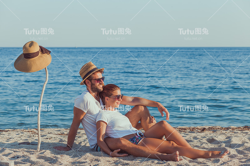 年轻情侣在沙滩上相爱，享受着