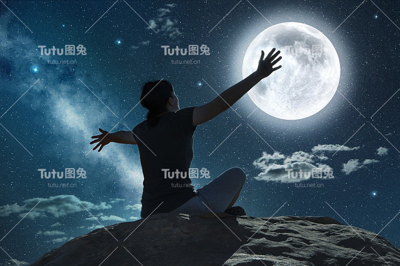 在月光下举起手臂的女人