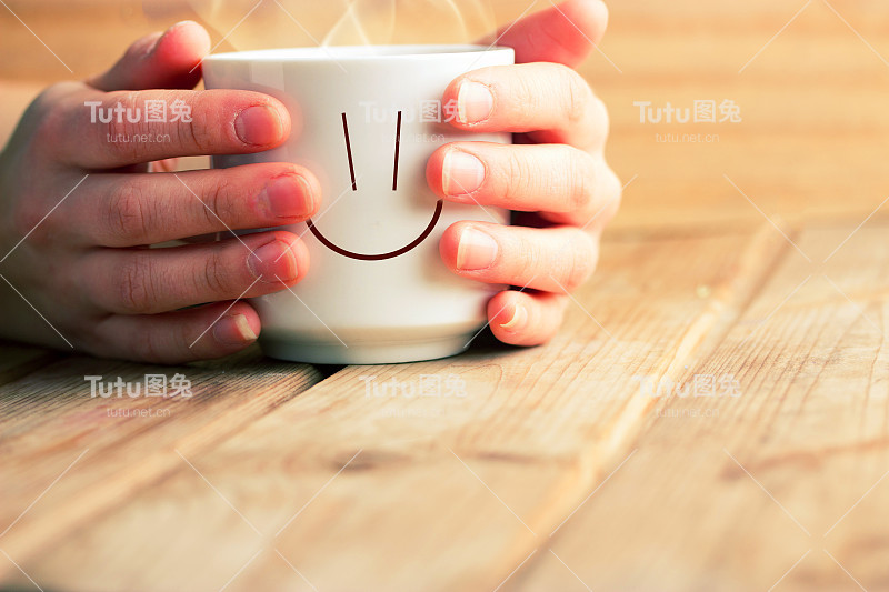 手里拿着一杯热茶或咖啡
