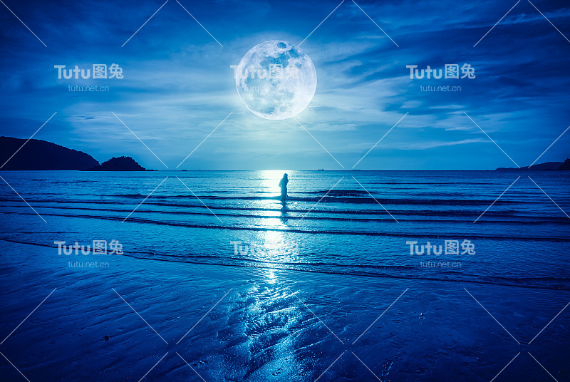 超级月亮。色彩斑斓的蓝天与云和明亮的满月在海景。