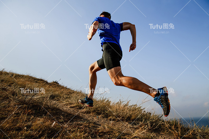 动态跑上坡的trail男运动员跑侧视图