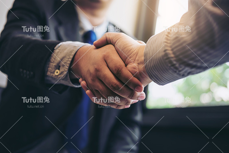 两个商人在会议期间握手，签署协议，成为一个商业伙伴，企业，公司，自信，成功的交易，他们的公司之间的合同