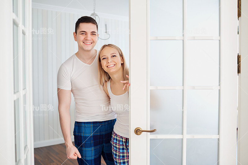 一对穿着睡衣的幸福夫妇邀请他们去他们家