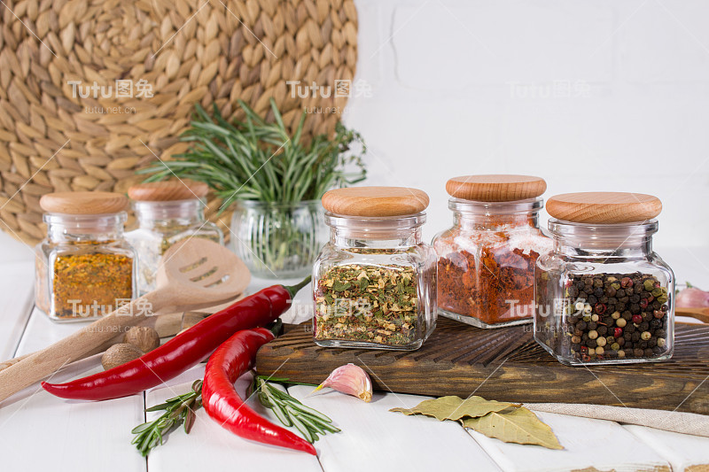 用于厨房烹饪的产品，厨房用具，药草，彩色的干香料，在白色的背景玻璃罐子