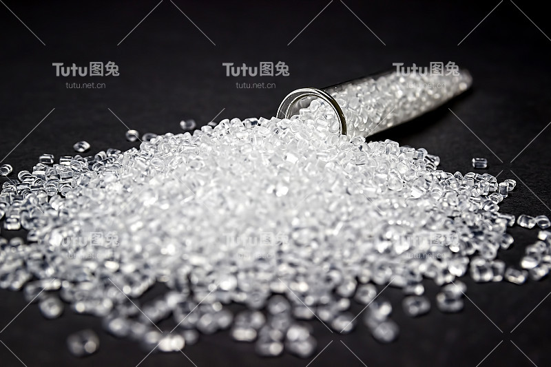 透明的塑料颗粒。聚合物颗粒。孤立在黑色背景上。