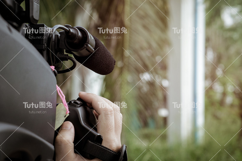 摄影师用摄像机在公园里拍摄视频。