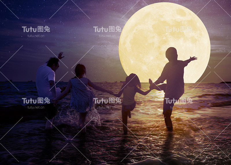 一家人在沙滩上玩，看月亮。庆祝中秋节的概念