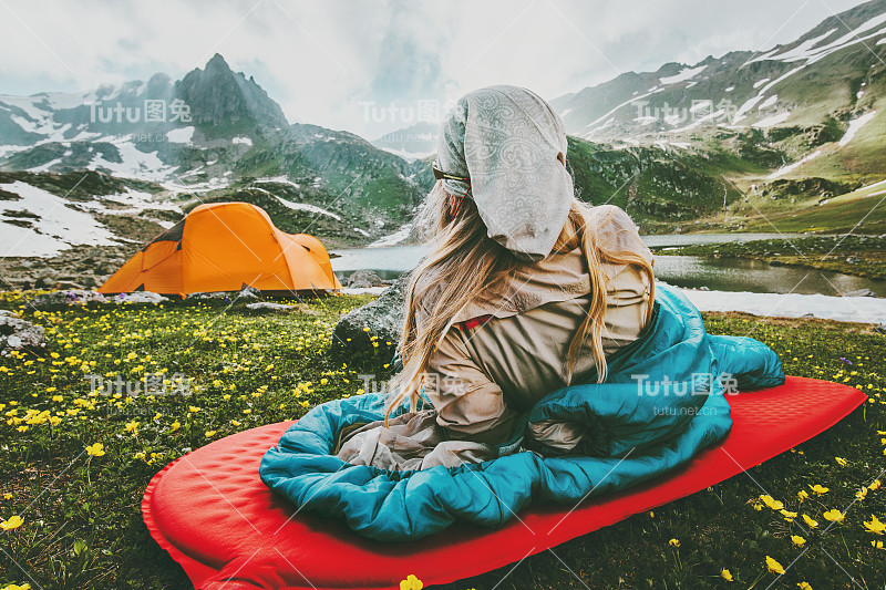 女人放松在红色垫子的睡袋露营旅行假期在山区生活方式概念冒险周末户外野生自然