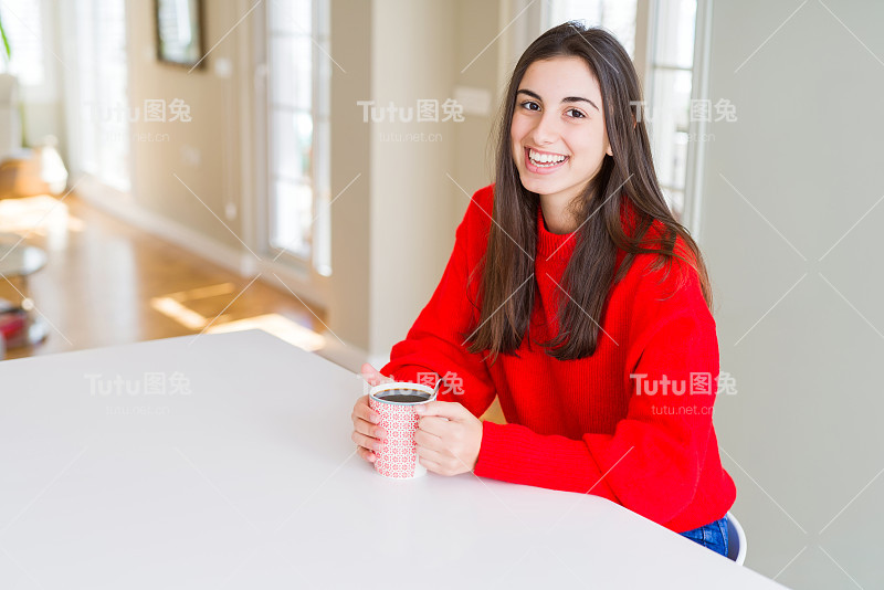 美丽的年轻女子正在享受一杯咖啡