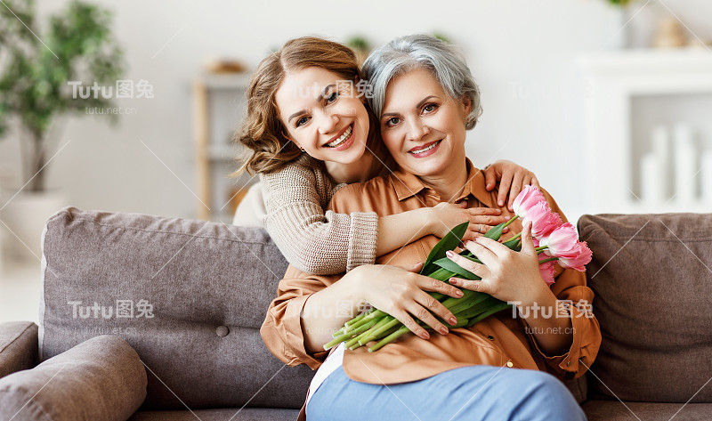 幸福的女人拥抱着年老的母亲和鲜花