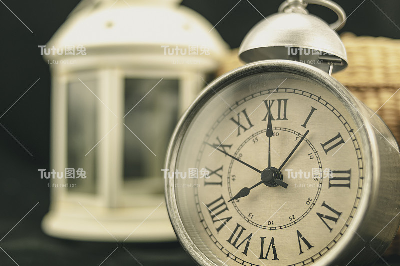 一个复古闹钟，背景是一个灯笼和一个篮子