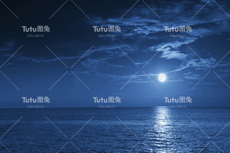 明亮的满月升起在一个平静的海景