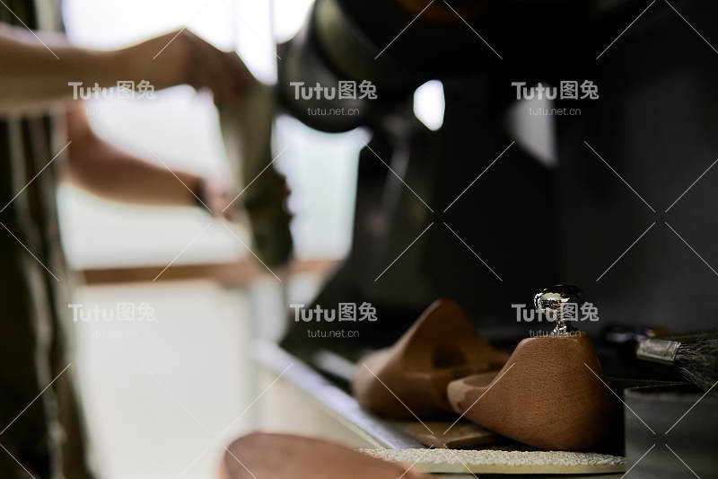 一个鞋匠在他的车间里刮一只鞋的模子