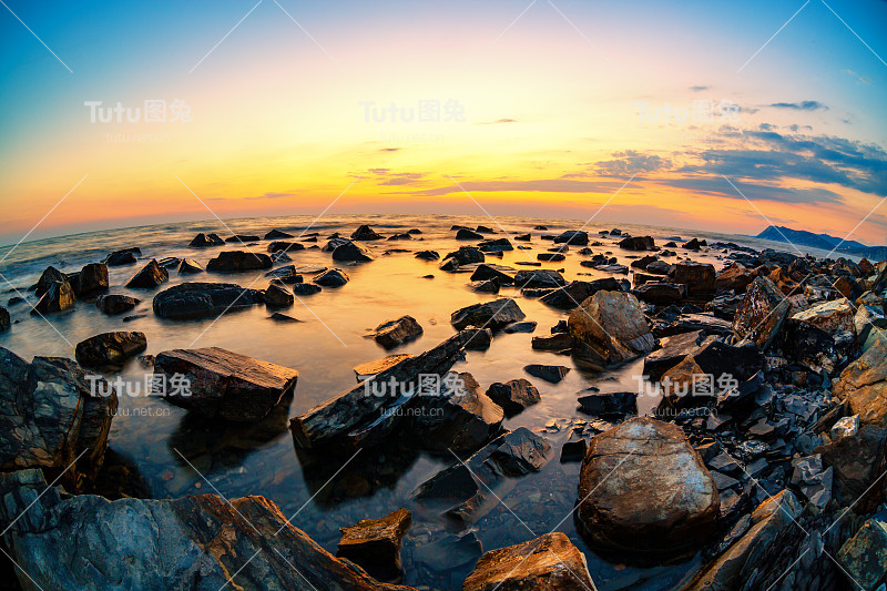 美丽的海景。日落与海的自然景观与石头。鱼眼镜头