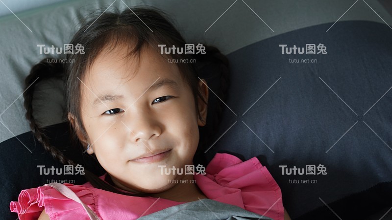 小女孩开心的笑着在床上醒来