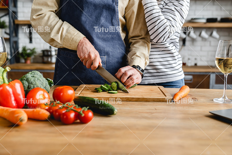 裁剪的图像美丽的资深夫妇在厨房一起做饭围裙