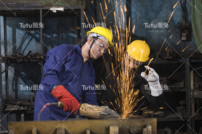 两名机械师在工厂使用圆锯磨床