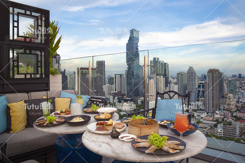 餐桌上的中国菜在屋顶酒吧与曼谷市
