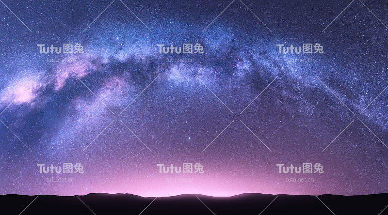 银河拱。美妙的夜景与明亮的拱形银河，紫色的天空与星星，粉红色的光和山丘。美丽的景象与宇宙。星空的空间背景。星系和自然
