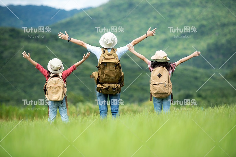 组团家庭儿童游自然之旅，举臂而立，户外看山，探险旅游为目的地休闲之旅