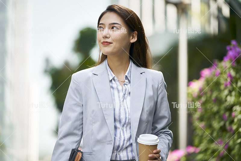 成功的年轻亚洲商业女性办公室职员走在大街上