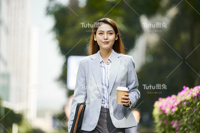 成功的年轻亚洲女性商业通勤走在街上