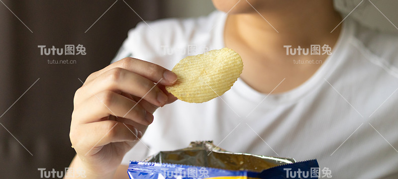 手拿薯片与零食袋