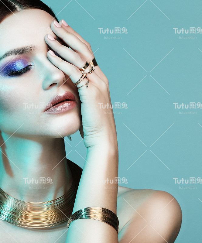 美丽的时尚模特穿着优雅的珠宝在色彩的光