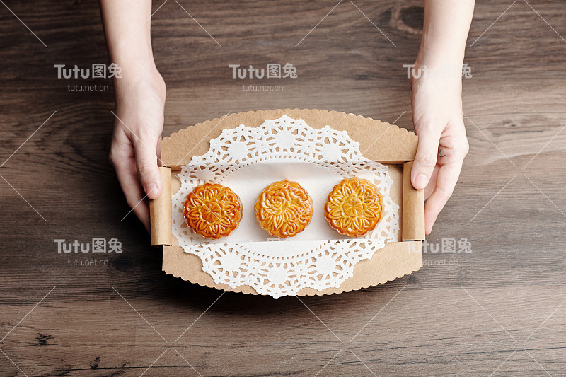 手拿一盒月饼的人