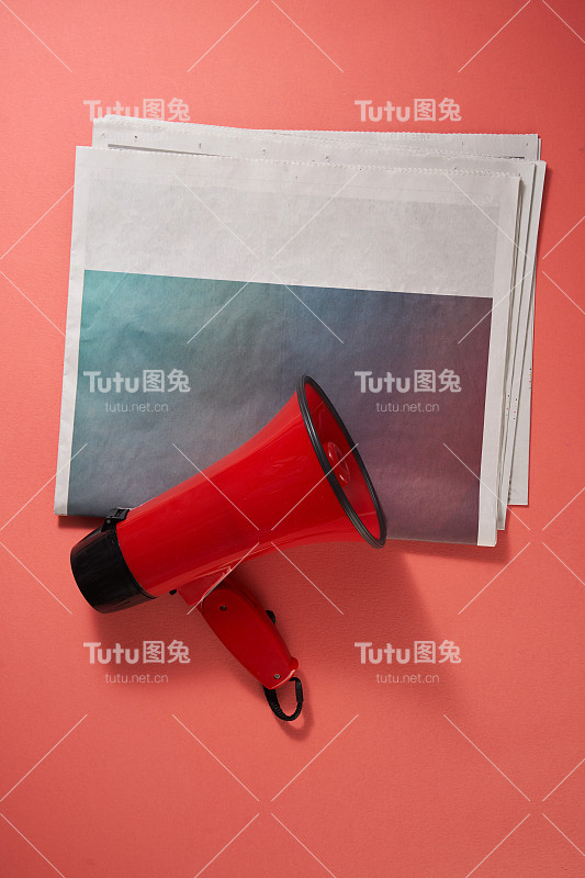 红色背景的报纸和扩音器