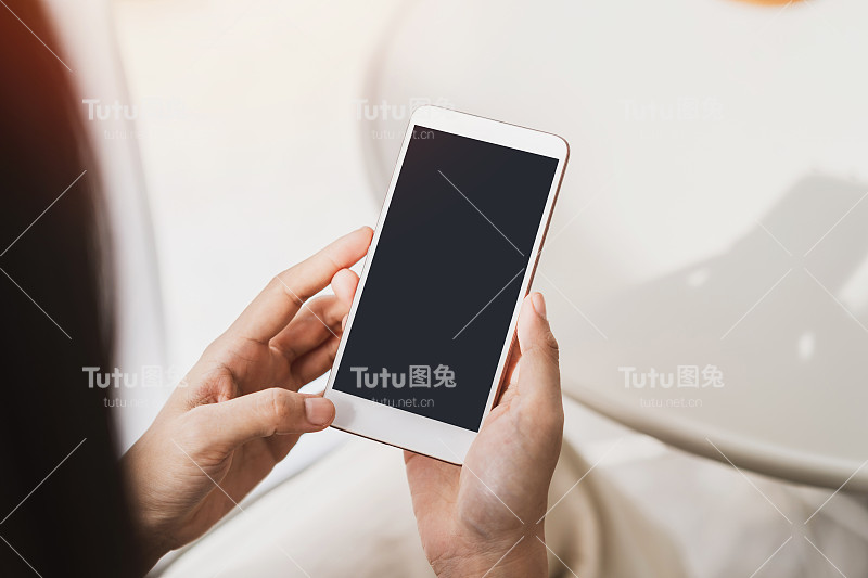 年轻女性使用智能手机和放松在咖啡馆，现代生活方式