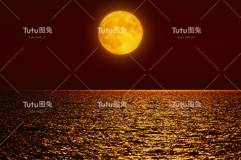 满月升上海洋的地平线。
