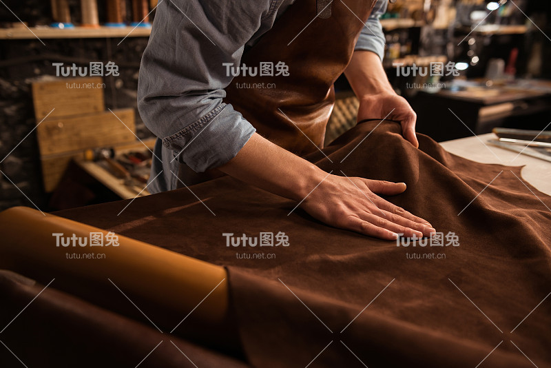 一个补鞋匠与皮革纺织品工作的特写