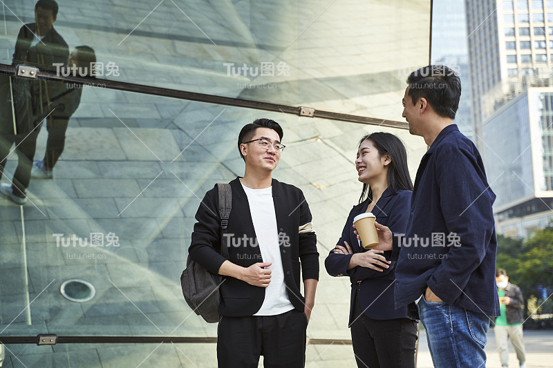 年轻的亚洲成年人站在街上聊天