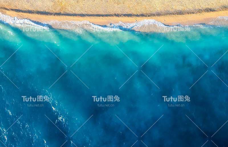 海岸与波浪作为背景从顶视图。蓝水背景从无人机。从空中俯瞰夏日海景。自然景观设计。