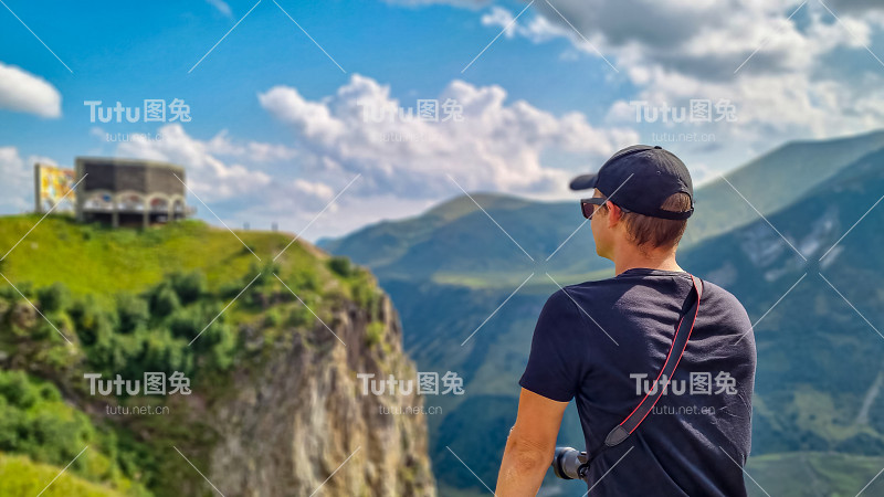 在格鲁吉亚的高加索山脉，一名男子正在观看格鲁吉亚友谊纪念碑。